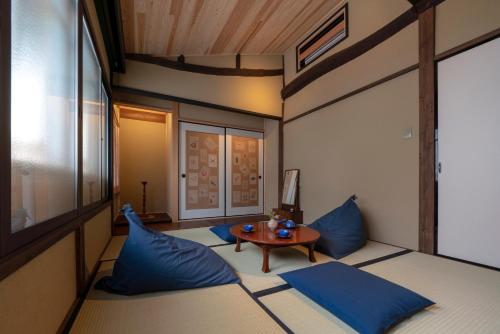 a small room with blue pillows and a table at Gion Shirakawa Kouki Machiya House in Kyoto