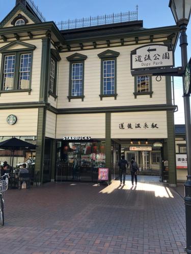 a large building with people walking in front of it at Hotel Patio Dogo in Matsuyama