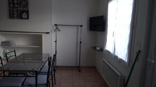 une salle à manger avec une table en verre et une fenêtre dans l'établissement Bellevue, à Saint-Paterne-Racan