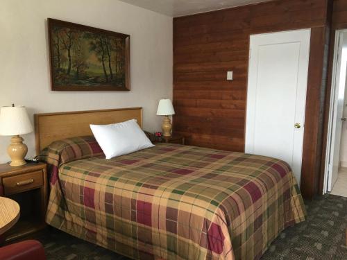 - une chambre avec un lit et une couverture tressée dans l'établissement Southsider Motel, à Coos Bay