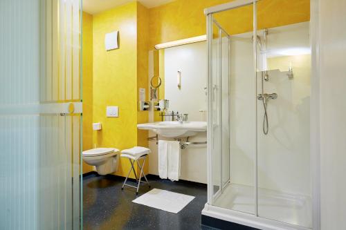 a bathroom with a shower and a sink and a toilet at Hotel Garni Colora in Bad Radkersburg