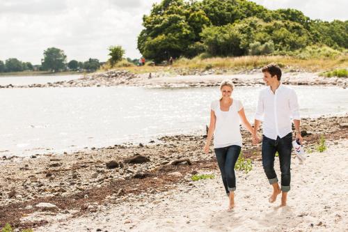a man and a woman walking along the beach at Hotel Birke, Ringhotel Kiel in Kiel