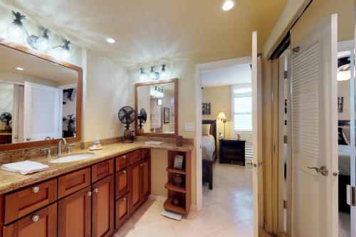 a bathroom with a sink and a large mirror at Nani Kai Hale in Kihei