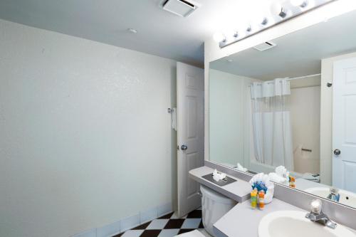 a bathroom with a sink and a mirror at Sunrise Suites Cat Island Suite #205 in Key West
