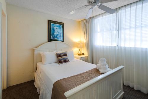sypialnia z dużym białym łóżkiem i oknem w obiekcie Sunrise Suites Cat Island Suite #205 w mieście Key West