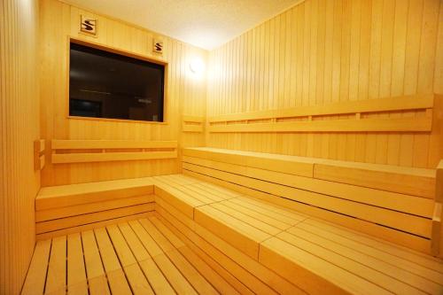 a sauna with wooden shelves and a flat screen tv at Hotel Abest Grande Okayama in Okayama