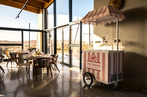 a food cart in a restaurant with tables and windows at The Desert Grace in Solitaire