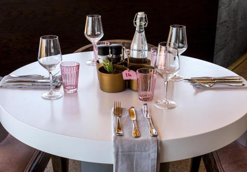 a white table with wine glasses and silverware at The Desert Grace in Solitaire