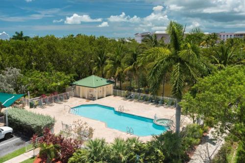 een uitzicht over een zwembad met palmbomen bij Sunrise Suites Saint Croix Suite #212 in Key West