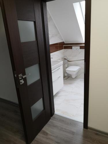 an open door to a bathroom with a toilet at Centrum Apartman LEYLA in Bardejov