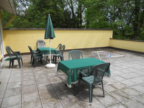 a patio with tables and chairs and an umbrella at Haus Hildegunde in Bad Füssing