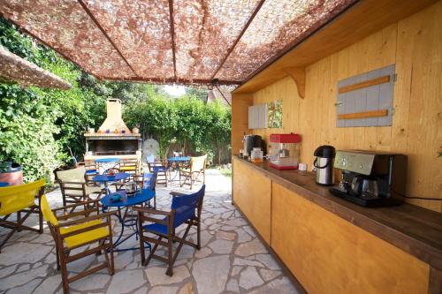 a patio with a table and chairs and a kitchen at Kalypso Studios & Apartments in Karavomylos