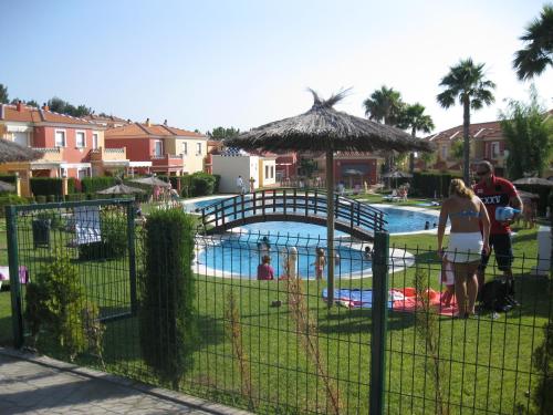 a group of people standing next to a swimming pool at APARTAMENTO PERFECTO in La Antilla