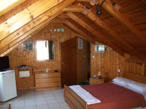 a bedroom with a bed in a wooden house at Nicolas Rooms in Fiskardo