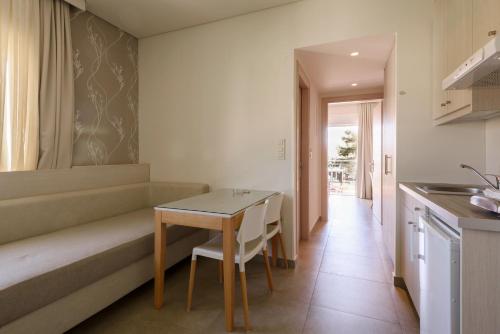 a living room with a table and a kitchen at Poseidon Studios & Apartments in Palaiochóra
