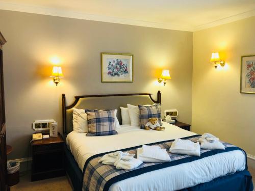 a hotel room with a bed with towels on it at Dryburgh Abbey Hotel in Melrose