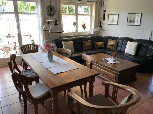 a living room with a table and a couch at "Kombüse" by Ferienhaus Strandgut in Born