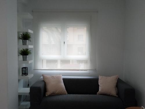 a couch in a living room with a window at Santos Studio 1 in Valencia