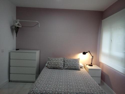 a small bedroom with a bed and a lamp at Santos Studio 1 in Valencia
