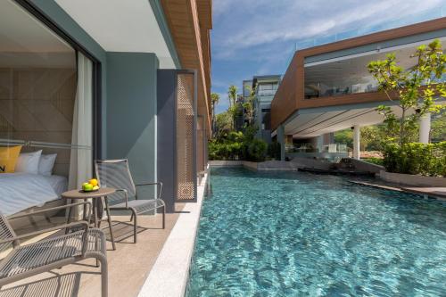 a hotel room with a bed and a swimming pool at The Nature Phuket - SHA Extra Plus in Patong Beach