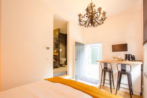 a bedroom with a bed and a table and a chandelier at Ververs slapen in Den Bosch