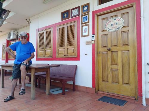 a man sitting on a table in front of a building at Edificio Magico in Tarrafal