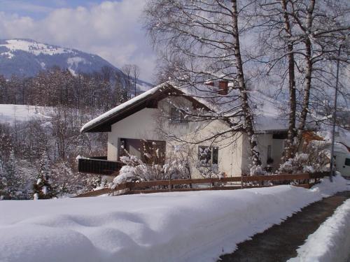 a house with snow on the ground and trees at Haus Kranzusch in Sonthofen