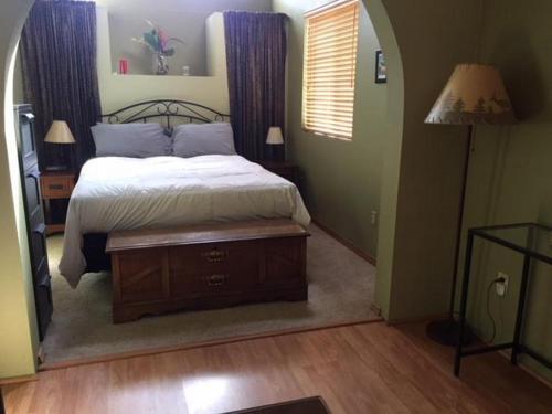 a bedroom with a bed and a table and a lamp at Waveseeker in White Salmon