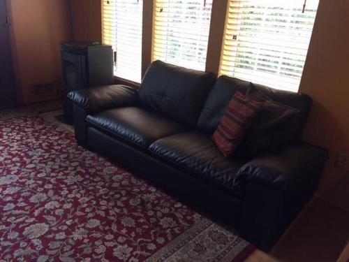 a black leather couch sitting in a living room at Waveseeker in White Salmon