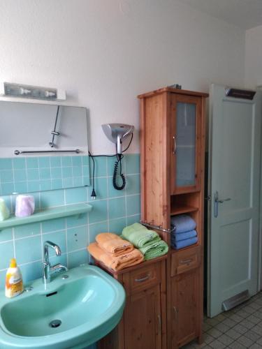 a bathroom with a sink and a cabinet with towels at Pension Haus Gertrud in Donauwörth
