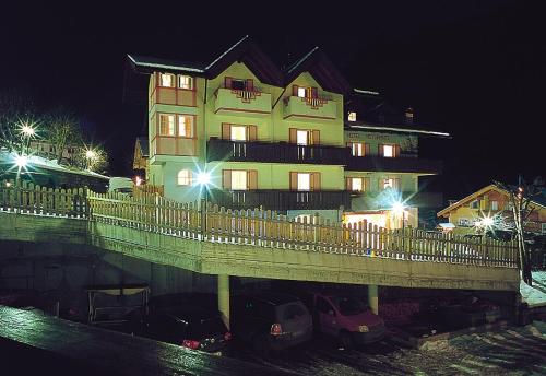 a large building with cars parked in front of it at Piccolo Hotel in Canazei