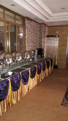 a long table in a room with chairs and umbrellas at Biraj International Hotel in Kampala