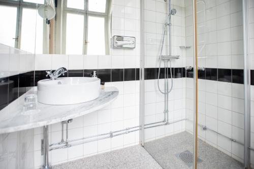 a bathroom with a sink and a shower at The Vault Hotel, WorldHotels Crafted in Helsingborg