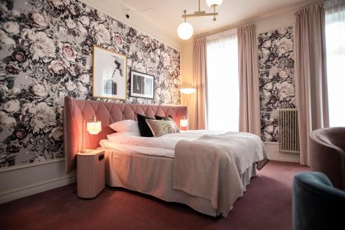a bedroom with a large bed with floral wallpaper at The Vault Hotel, WorldHotels Crafted in Helsingborg