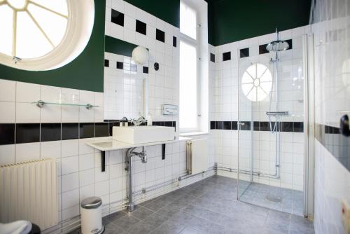 a bathroom with a sink and a shower at The Vault Hotel, WorldHotels Crafted in Helsingborg