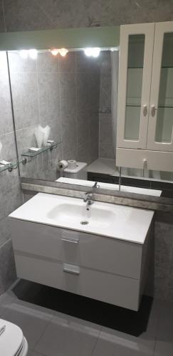 un bagno con un lavandino bianco e uno specchio di New Go Inn a Madrid