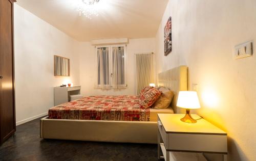Dormitorio pequeño con cama y lámpara en Relax Suite Nazario, en Bolonia