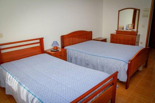 a bedroom with two beds and a mirror at Hospedaria Santa Cruz in Seia