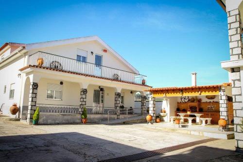 a large white house with a balcony and a patio at Hospedaria Santa Cruz in Seia