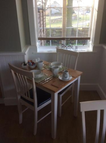 a dining room table with chairs and a table and a window at Mill Croft Bed and Breakfast in Goathland