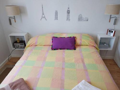 モグロにあるTerraza de Mogroのベッド1台(カラフルな毛布、紫色の枕付)