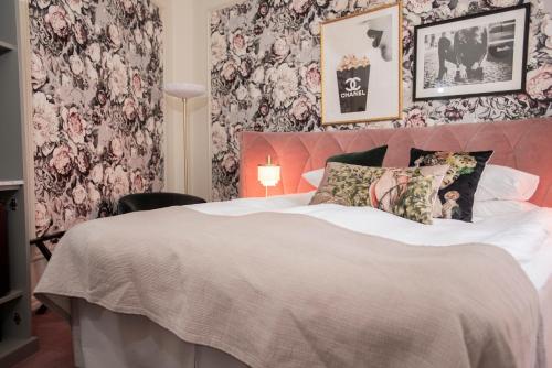 a bedroom with a large bed with floral wallpaper at The Vault Hotel, WorldHotels Crafted in Helsingborg