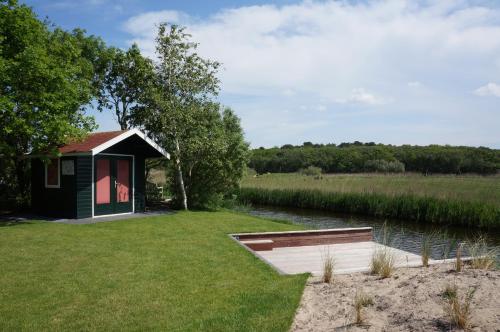 a small cabin on the side of a river at Buitenplaats Villa Deluxe in Callantsoog