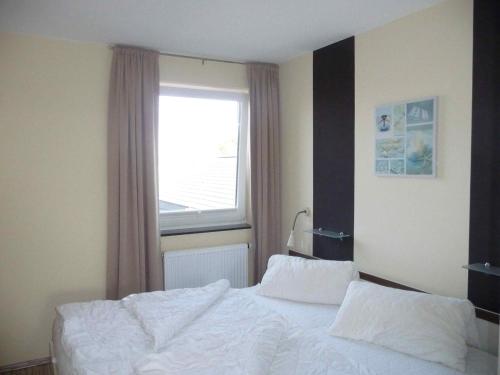 StaberdorfにあるSTHS78213-FeWo-Fehmarnstrand-IIのベッドルーム(白いベッド1台、窓付)