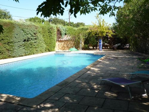 - une piscine avec une table et une chaise dans la cour dans l'établissement " le bosquet fruité en Provence Occitane, à Bagnols-sur-Cèze