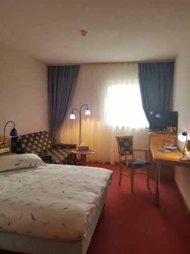 a hotel room with a bed and a desk and a chair at Iris Hotel in Oradea