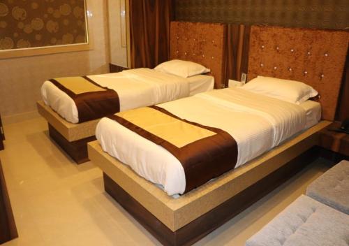 two beds in a hotel room with at Hotel Angina in Kolkata