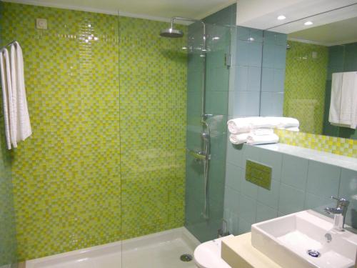 a bathroom with a glass shower and a sink at INATEL Porto Santo in Porto Santo