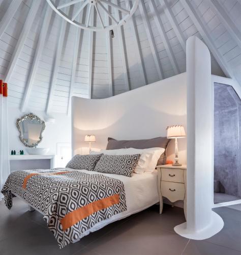 a white bedroom with a bed and a white ceiling at Absolute Mykonos Suites & More in Mikonos