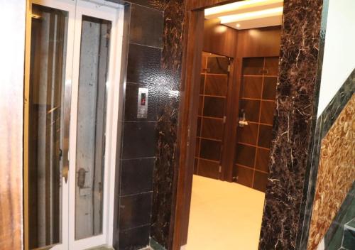 a bathroom with a shower with a glass door at Hotel Angina in Kolkata